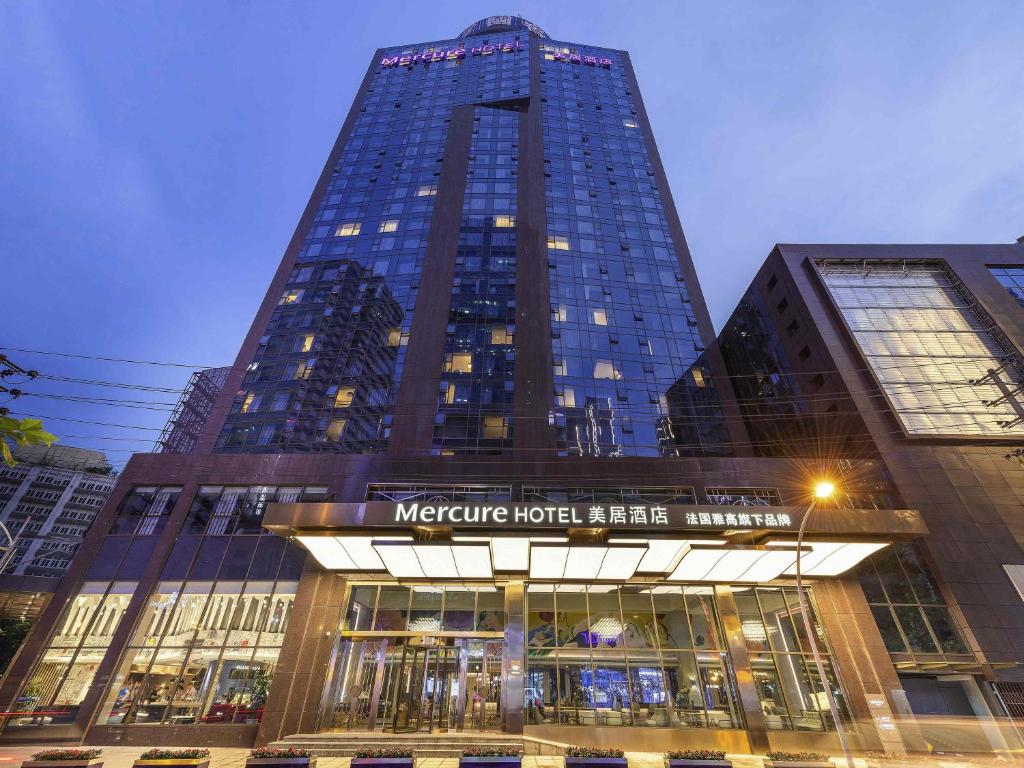 成都Chengdu Taikoo Li Chunxi Mercure Hotel的一座前面有标志的高楼