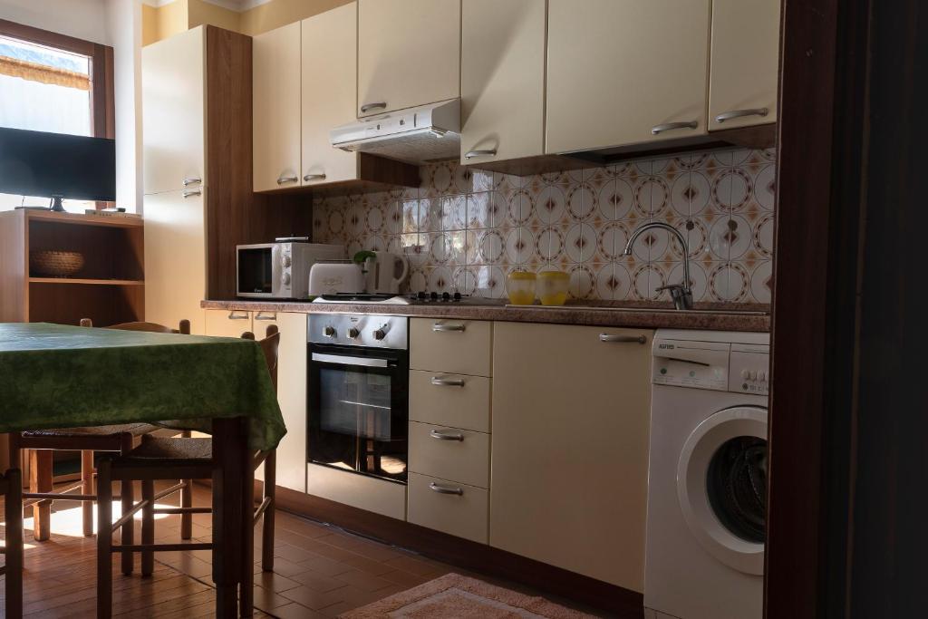a kitchen with a stove and a washing machine at Case Gran Paradiso Rhemes Notre Dame Piazza in Rhêmes-Notre-Dame