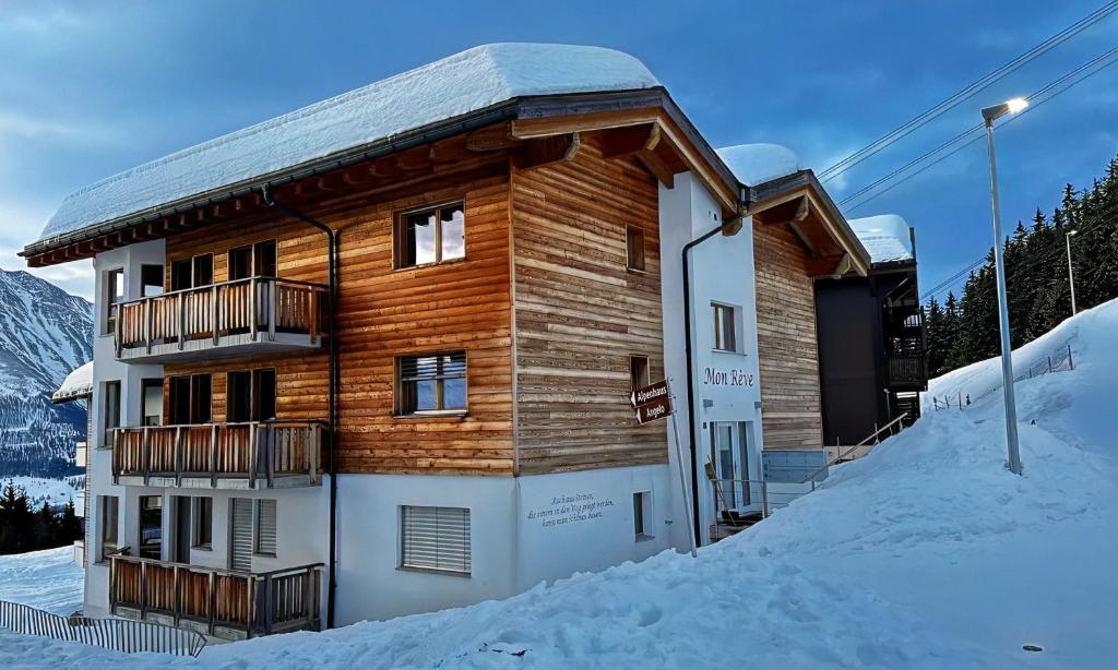 a wooden building with a balcony in the snow at Mon Rêve Bijou in Bettmeralp