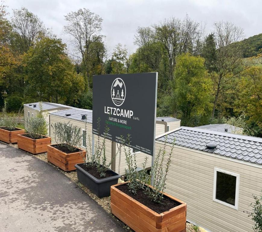 a sign for a garden with pots of plants at LetzCamp Mullerthal-Lodge 6 Pers in Beaufort