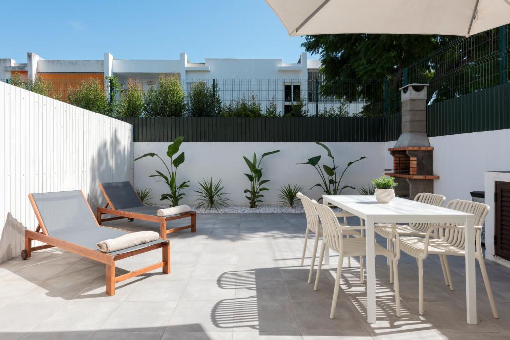 a patio with a table and chairs and a white fence at NUZZA - Vilamoura Marina with BBQ in Vilamoura