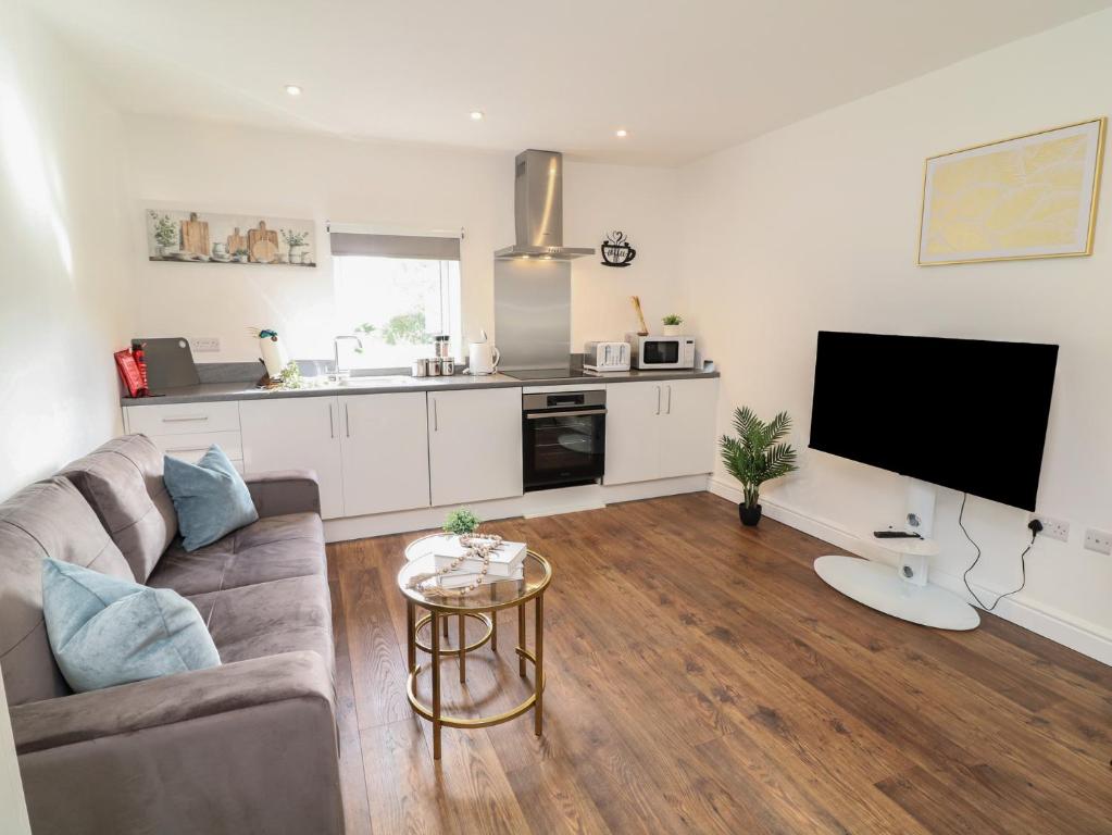 a living room with a couch and a flat screen tv at Four in Peterborough