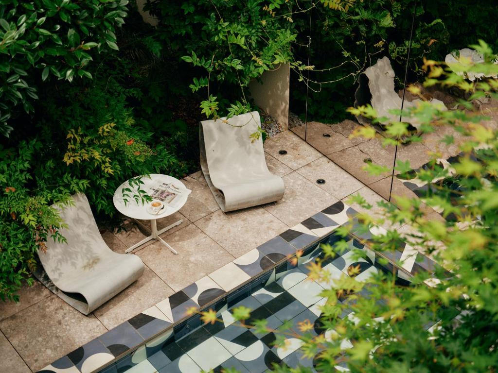 2 sillas y una mesa en un jardín en Hotel Ploberger, en Wels