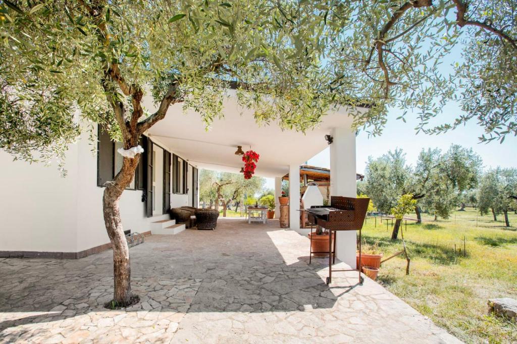 a white house with a tree and a piano at Villetta in San Giovanni Rotondo