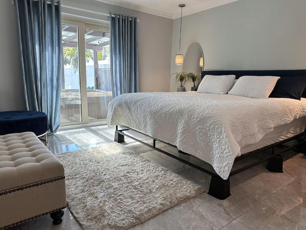 a bedroom with a large bed and a chair at Newly Renovated Villa with Hot Tub in Fort Lauderdale