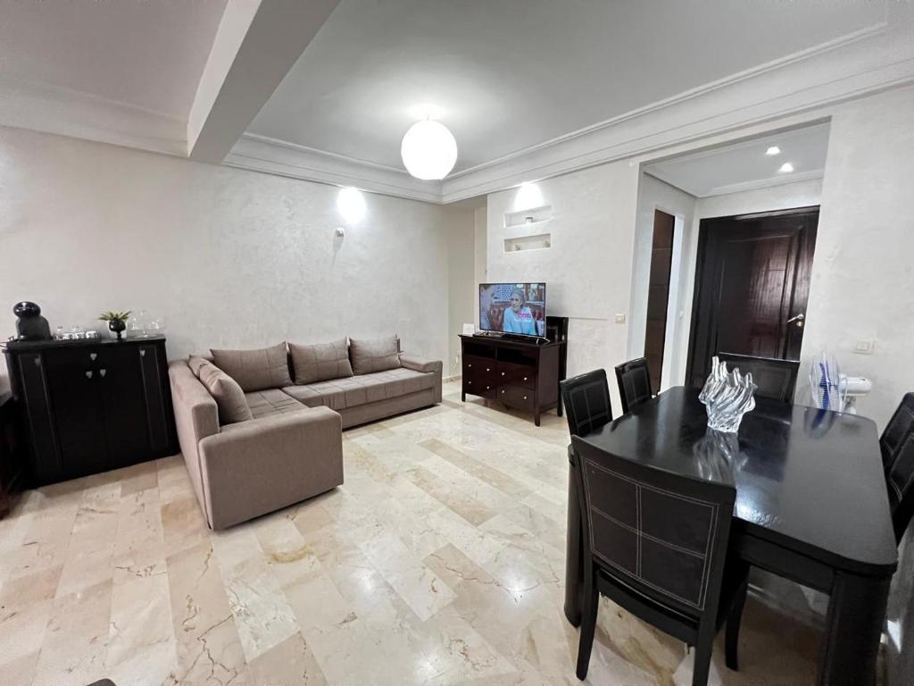 a living room with a table and a couch at Corniche Casablanca in Casablanca