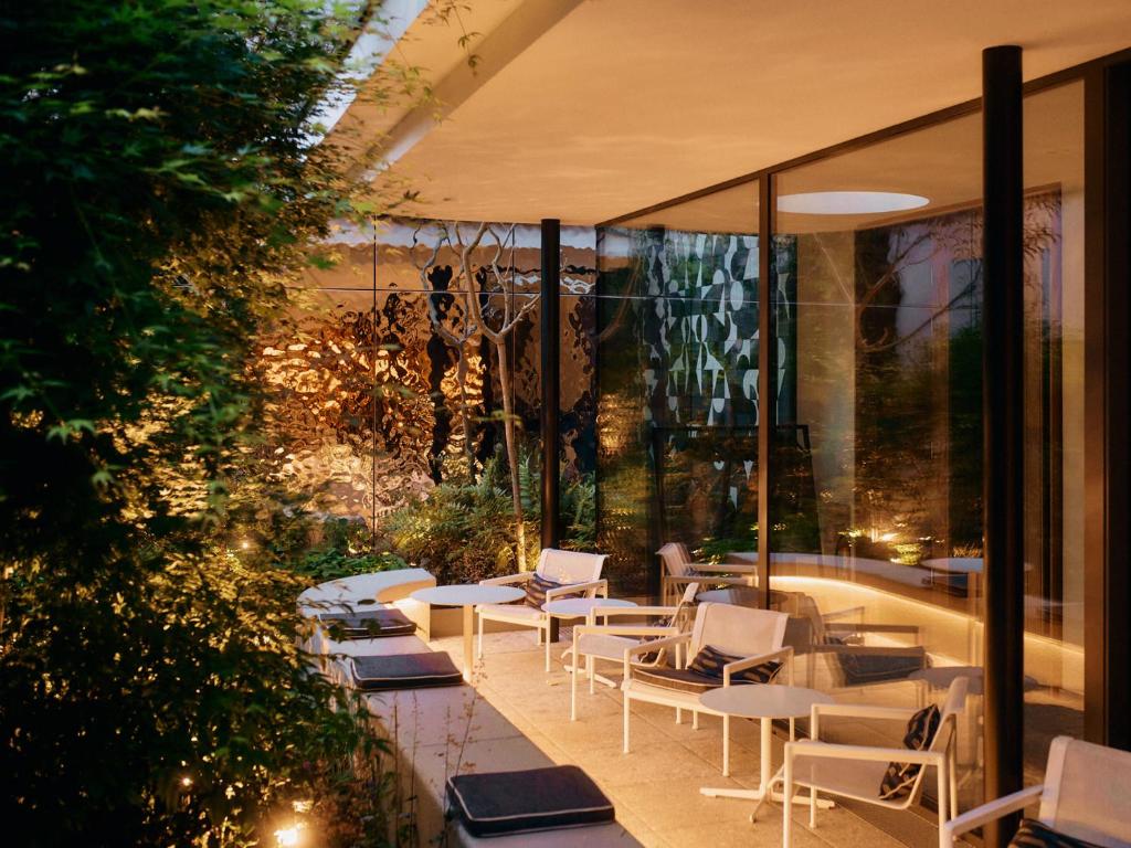 a patio with white chairs and tables in a building at Hotel Ploberger in Wels