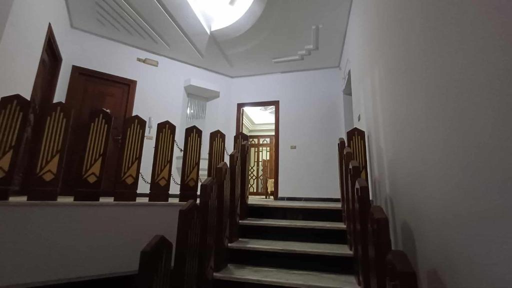 a row of pews in a church with a door at Azur villa in Sfax
