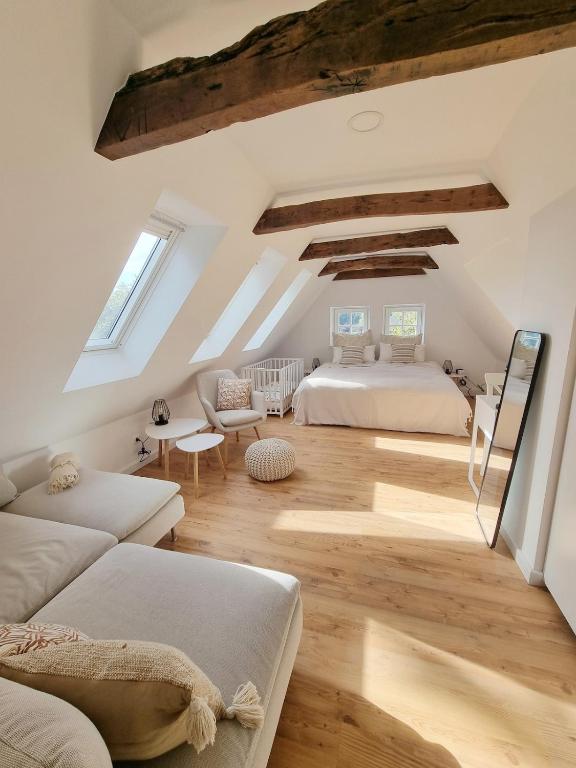 a attic bedroom with two beds and a couch at Lichtdurchflutete Dachgeschosswohnung mit Charme in Goldenstedt