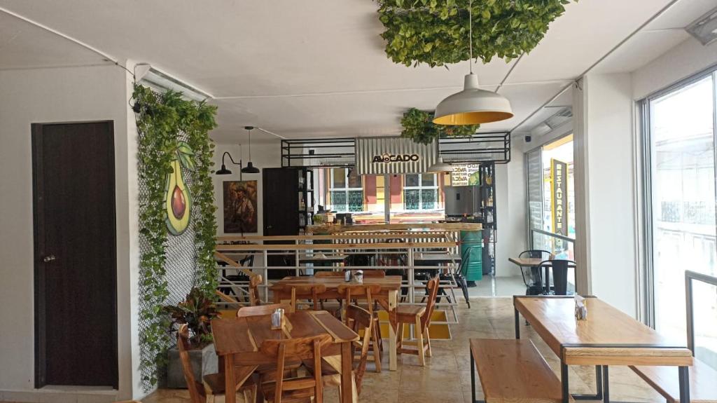 un restaurant avec des tables et des chaises en bois et des plantes dans l'établissement Hotel San Miguel src, à Santa Rosa de Cabal