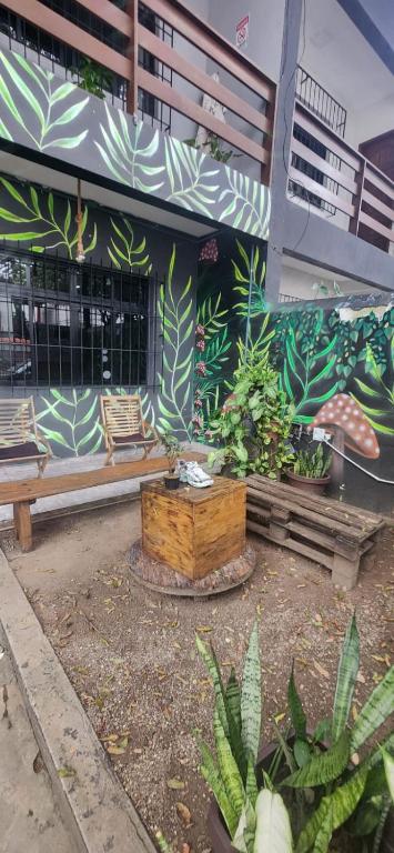 a building with a bench and plants in front of it at Jeremias Hostel Bar in Vila Velha