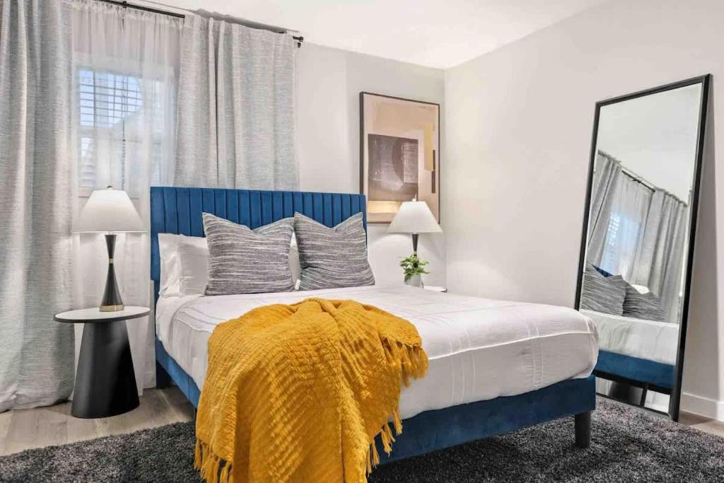 a bedroom with a bed with a yellow blanket on it at Steps away from Downtown Restaurants and Bars - King Bed in Austin