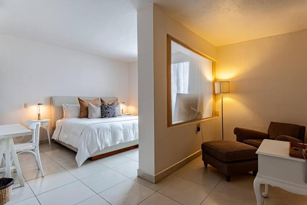 a bedroom with a bed and a table and a chair at Majestic Colonial Villa Private Pool Jacuzzi and Gardens in Ocotepec