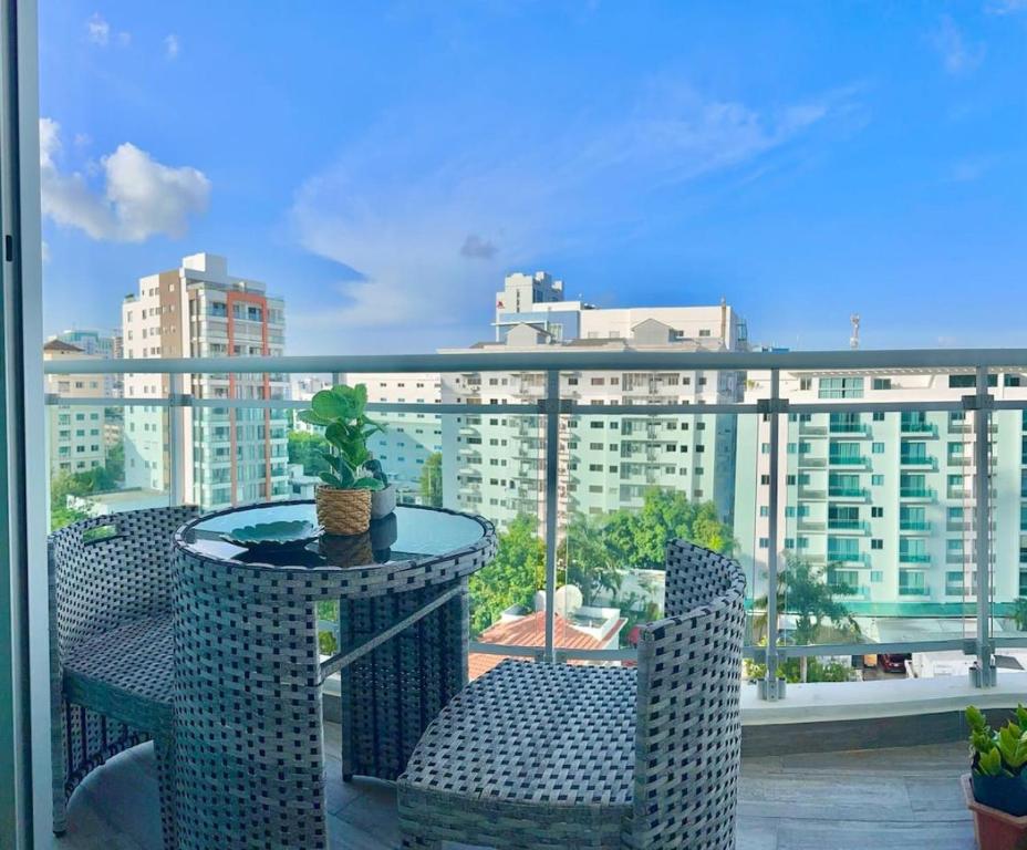 a table and chairs on a balcony with a view of a city at Chic Elegant City Center Condo in La Julia