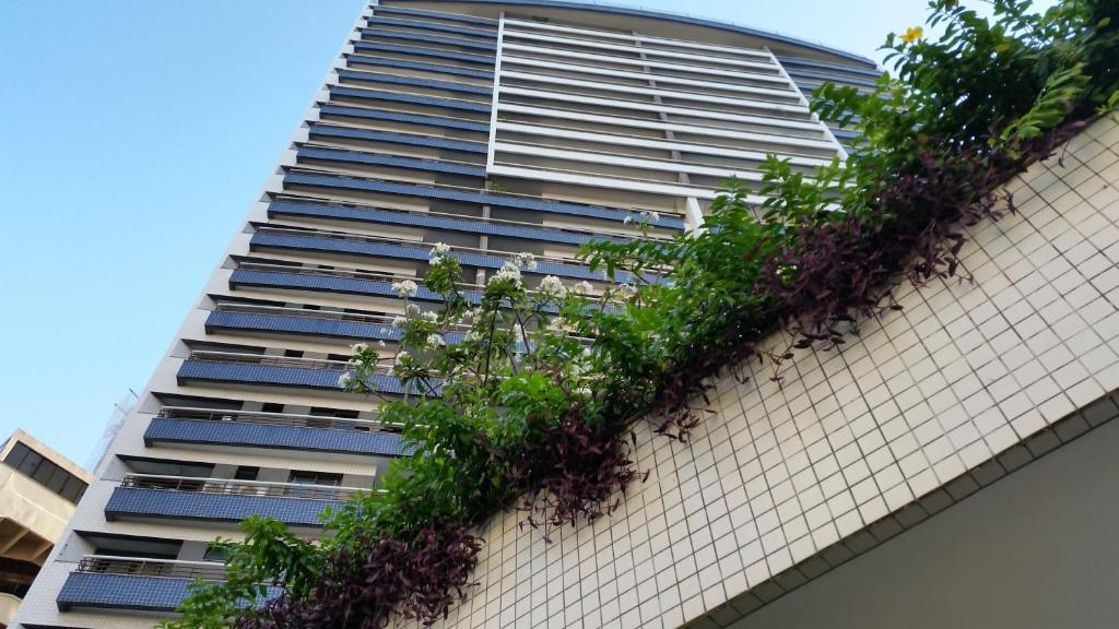 un edificio alto con plantas a su lado en Amazonia Residence 3 Quartos, en Fortaleza