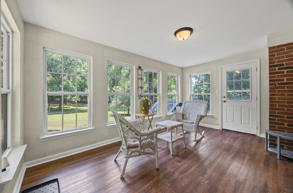 a living room with a table and chairs and windows at Shalom Home in Charlotte