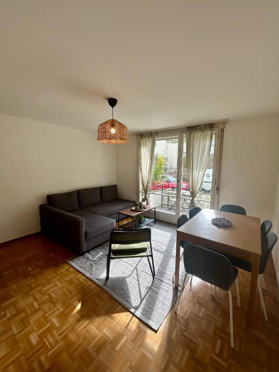 a living room with a couch and a table and chairs at Basic Flat with Balcony in Zurich in Zurich