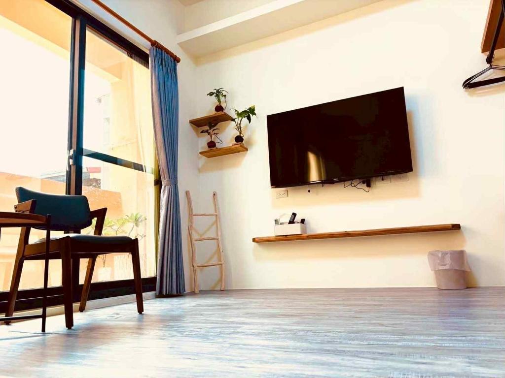 a living room with a flat screen tv on a wall at 竺韵旅宿 in Zhushan