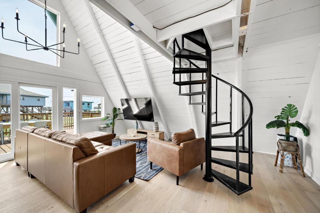 a living room with a spiral staircase in a house at Cozy A-frame with Fenced Yard, Fire Pit, Gulf View in Surfside Beach