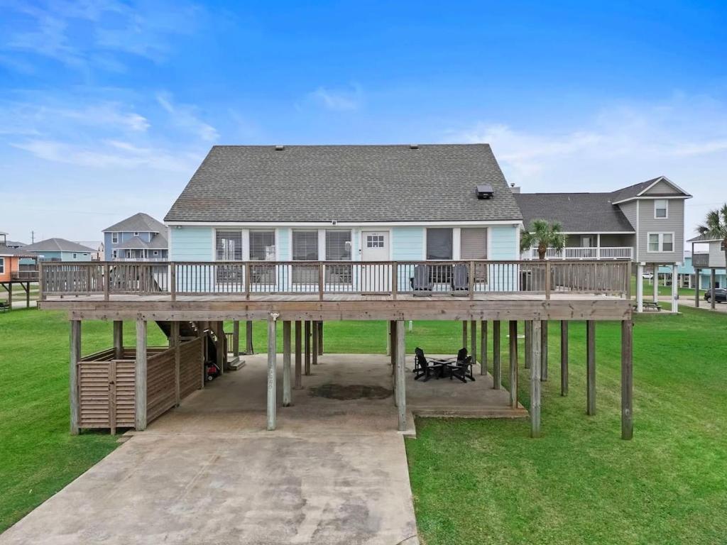 a large house with a large wooden deck at Bright and Cozy 4 Bedroom close to the Ocean in Galveston