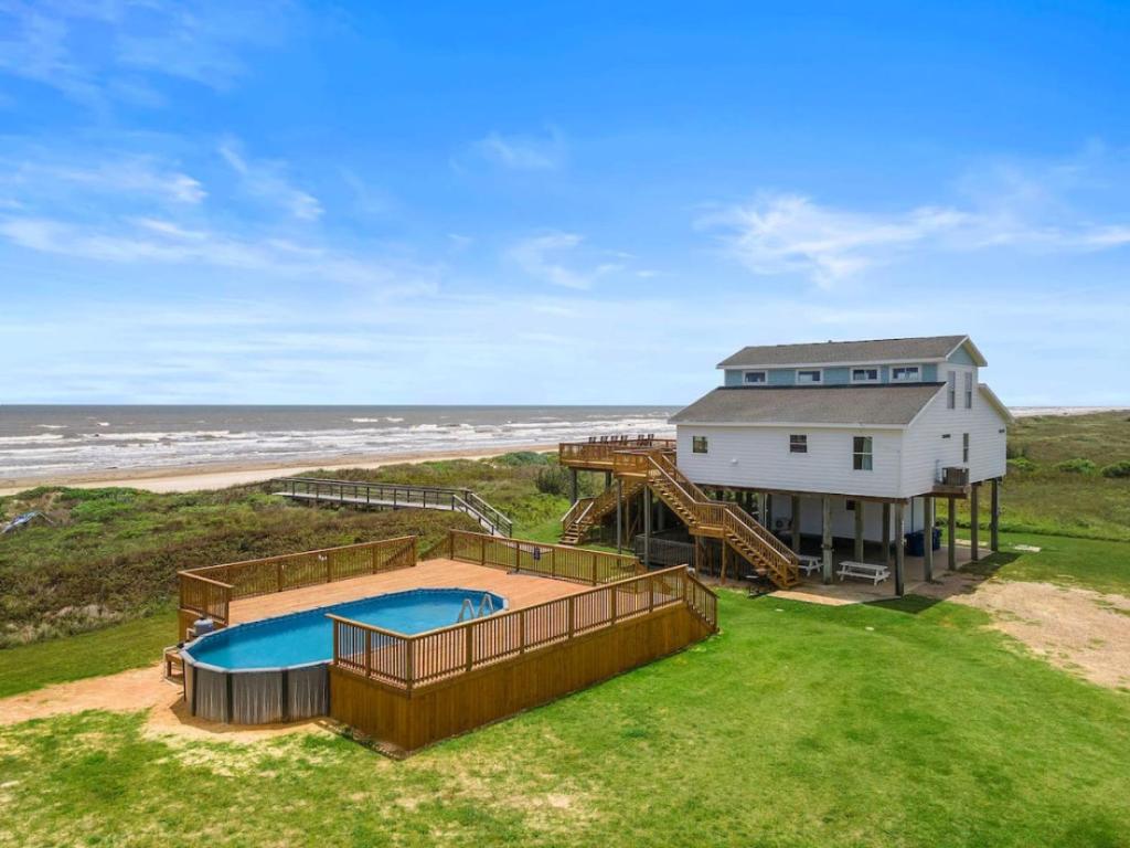een luchtfoto van een huis met een zwembad bij Secluded beachfront home with panoramic ocean views, private pool and huge deck in Hercules Offshore Heliport