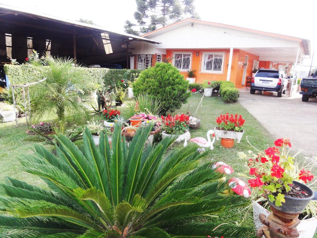 un jardín con flores y plantas frente a una casa en Orange House Canela, en Canela