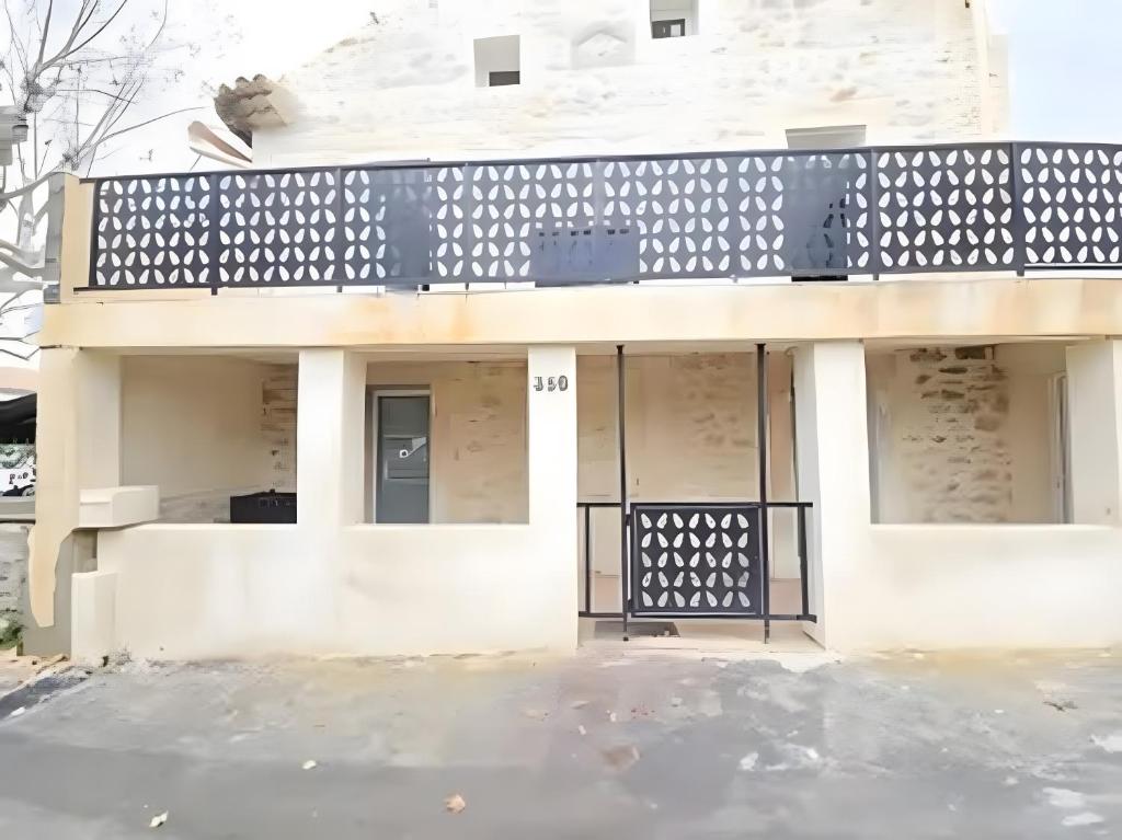 Un edificio blanco con una valla negra delante. en Canto Cigalo Duplex no 11, en Robion en Luberon