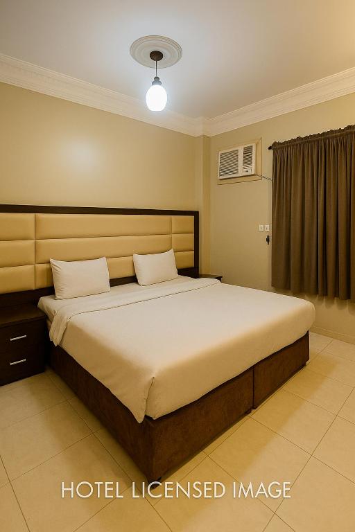 a bedroom with a large bed with aigil leased image at نوارة المنسك للشقق الفندقية in Abha