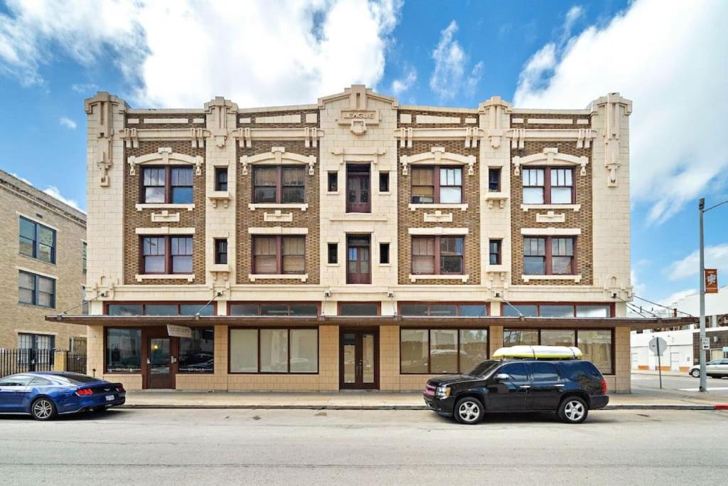 Historic loft in downtown Galveston close to everything في جالفيستون: مبنى به سيارات متوقفة أمامه