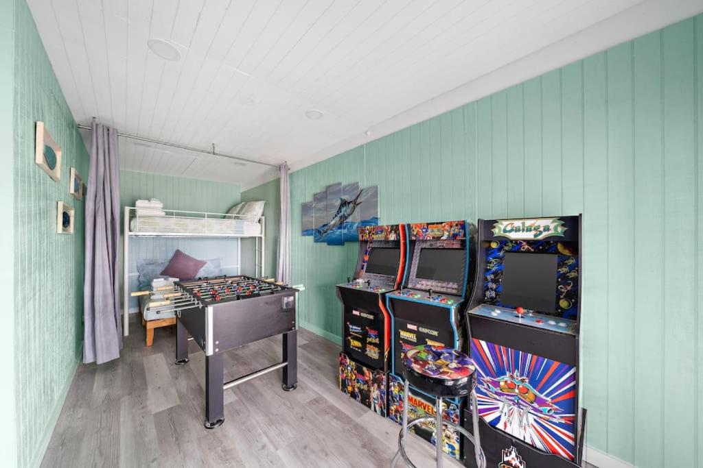 加尔维斯敦Waterfront canal with stunning pool and direct fishing access的一间设有两个街机游戏和一张床的房间