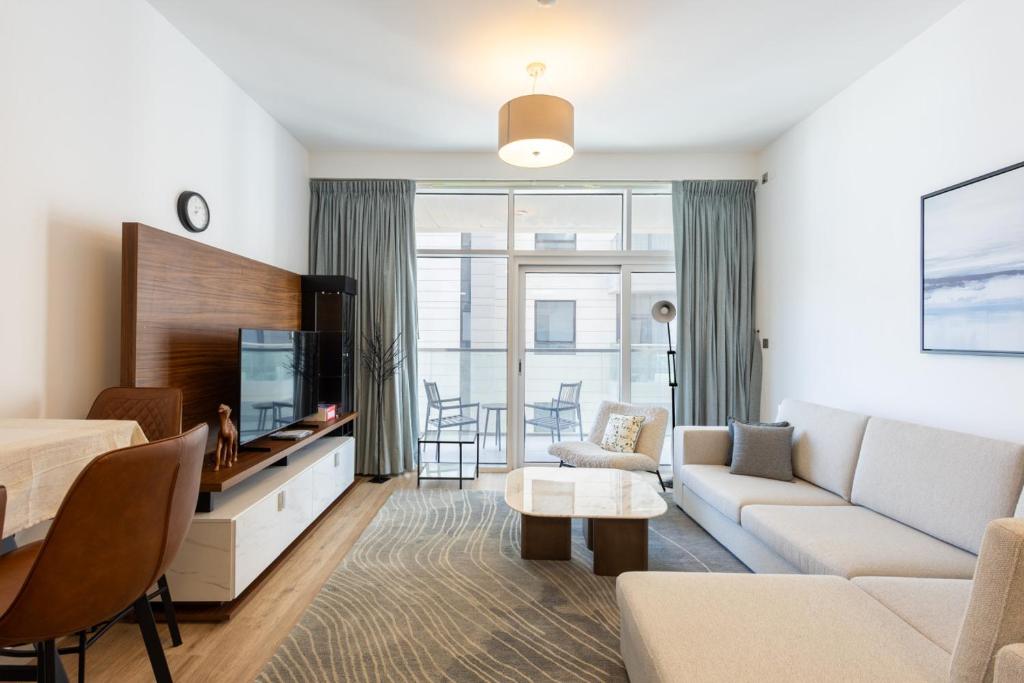 un soggiorno con un divano e una TV di Parkside Serenity Stunning Open View 1 bedroom a Mushayrib