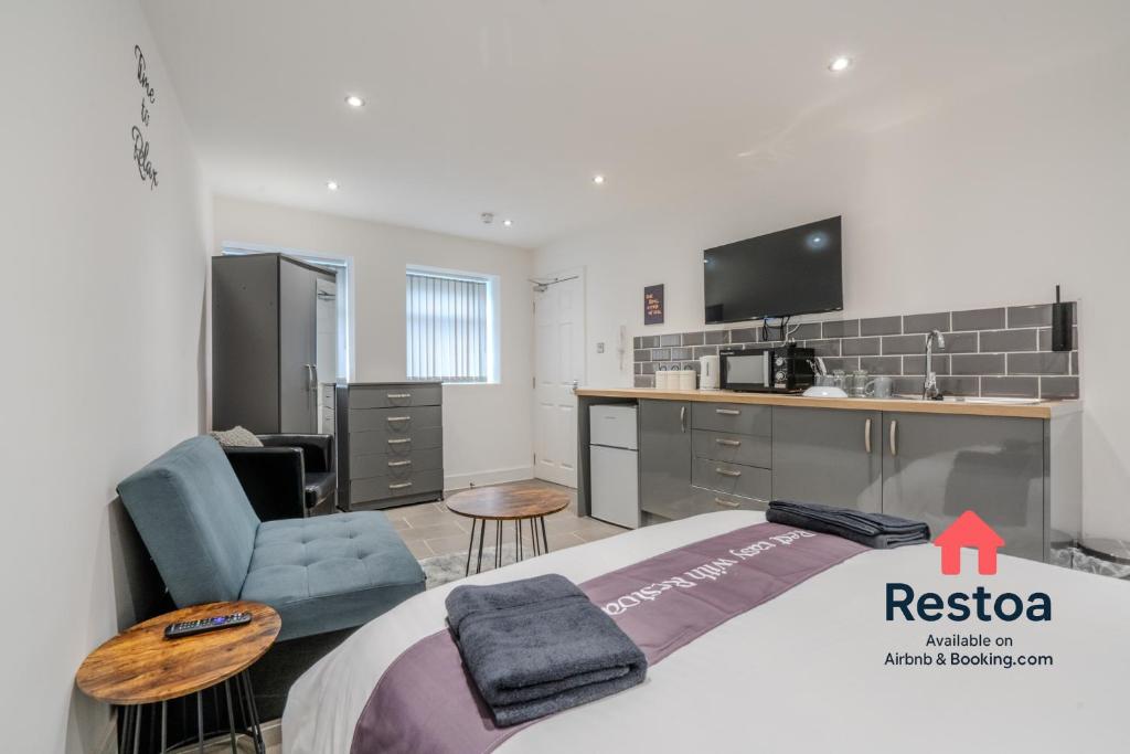 a bedroom with a bed and a tv and a chair at Neepsend Lane Studios in Neepsend