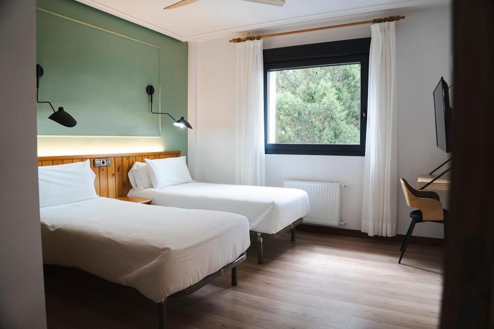 a hotel room with two beds and a window at El Ciervo in Villaciervos