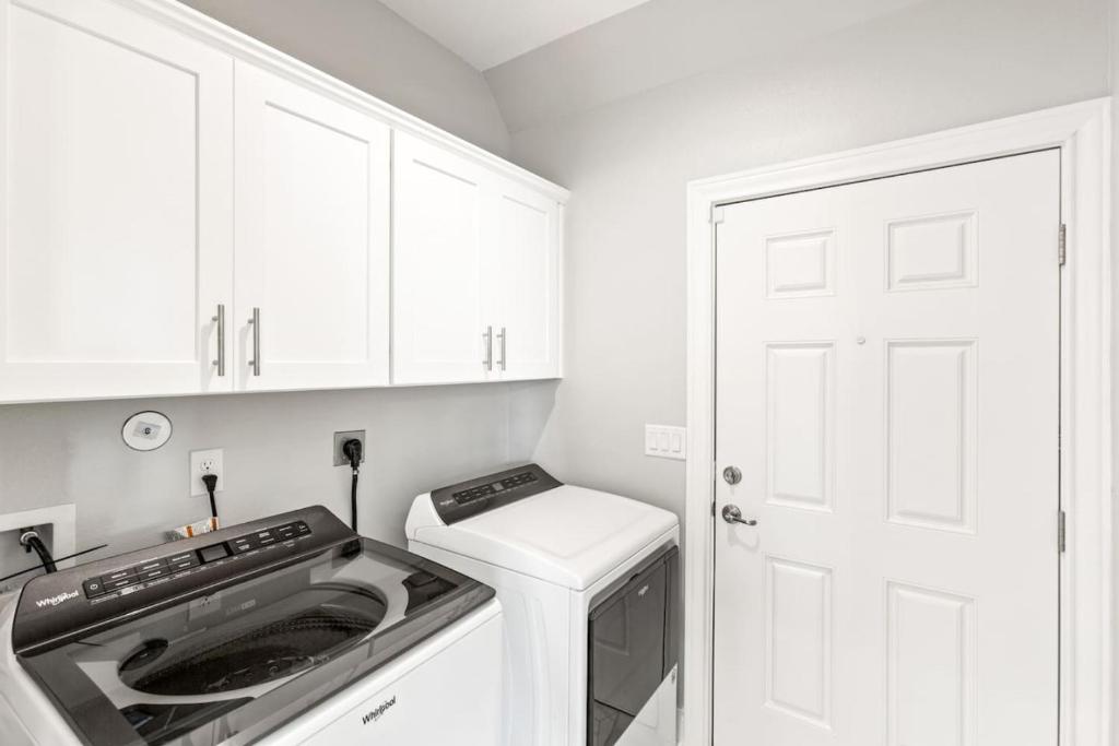 a kitchen with a stove and a washer and dryer at Family Friendly 3-Bedroom Coastal Escape in Galveston