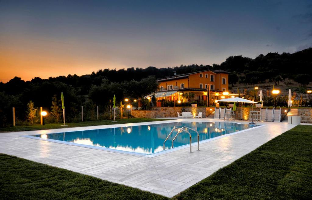 a large swimming pool in front of a house at Casale degli Ulivi Resort in Pellare