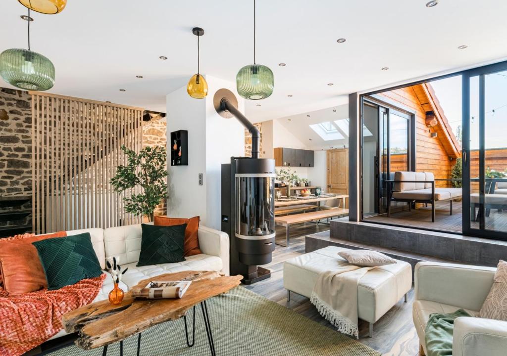 a living room with a couch and a fireplace at Le Rooftop Loft premium 3 chambres avec terrasse & parking en centre-ville de Saint-Étienne in Saint-Étienne