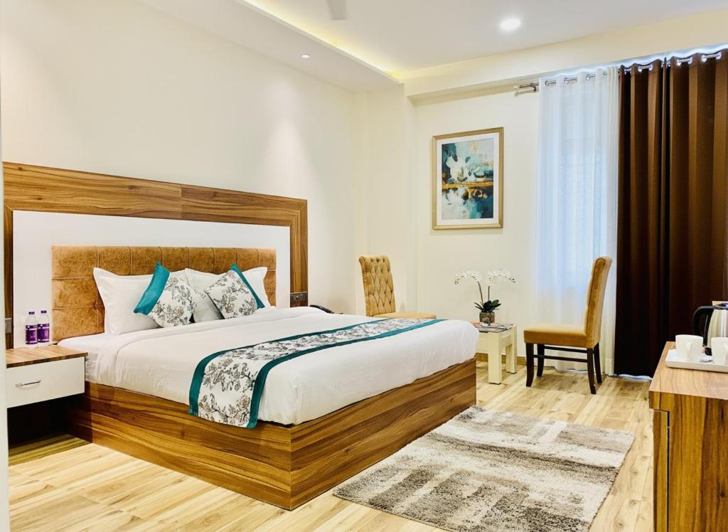 a bedroom with a king sized bed and a desk at Hotel White Amritsar - A Luxury stay near golden temple in Amritsar