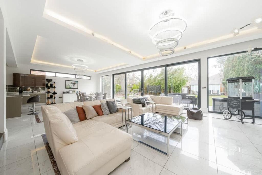 een grote woonkamer met witte meubels en grote ramen bij Exceptional Luxury w Leisure Facilities in Teddington
