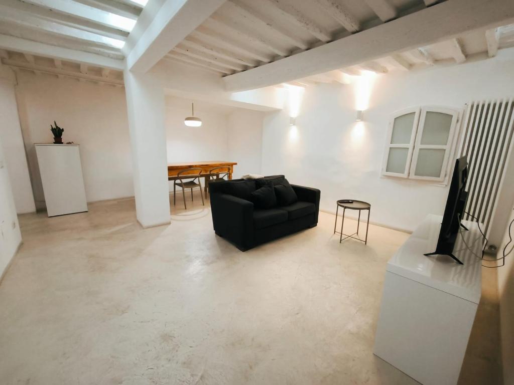 een woonkamer met een zwarte bank en een tafel bij Sassoverde 9 in Arezzo