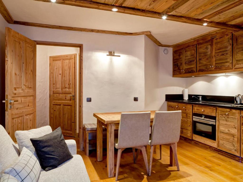 a kitchen and dining room with a table and chairs at Appartement de standing au centre de Courchevel 1850, en bord de piste et avec terrasse - FR-1-514-35 in Courchevel