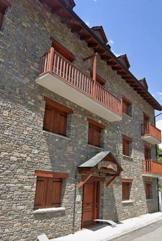 a brick building with a balcony on the side of it at Dúplex a 20 min de Aigüestortes in Escaló