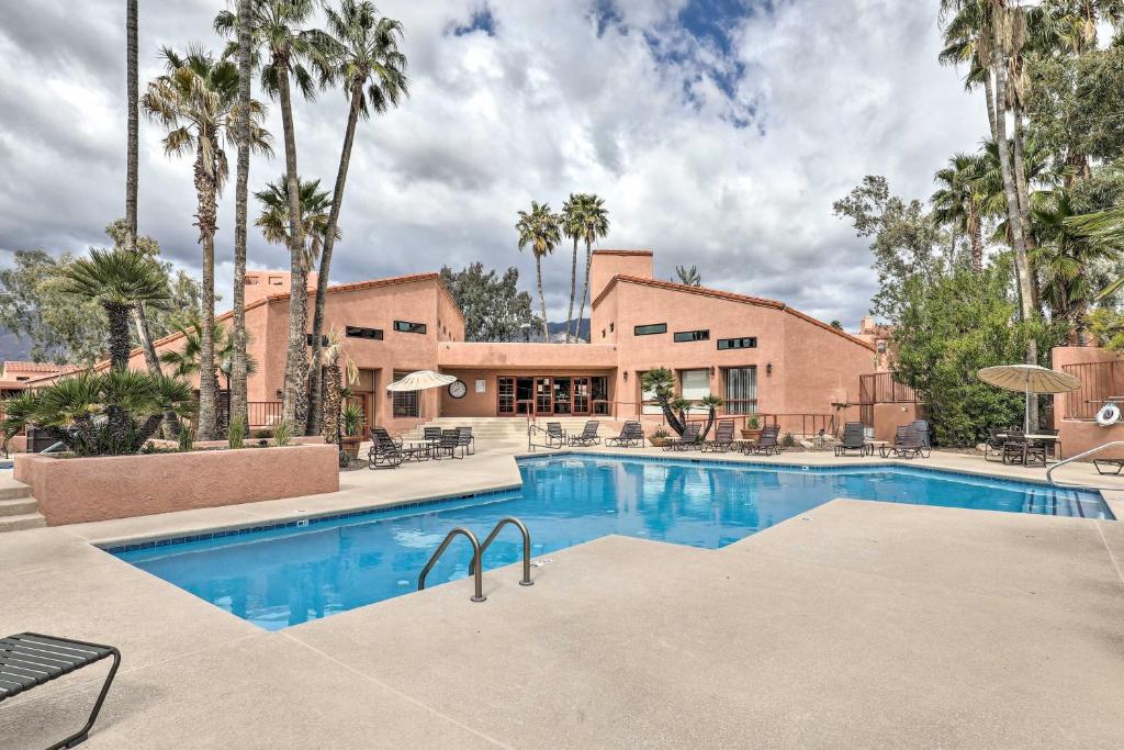a swimming pool in front of a building with palm trees at 3 Mi to Sabino Canyon Condo with Resort Perks! in Tucson