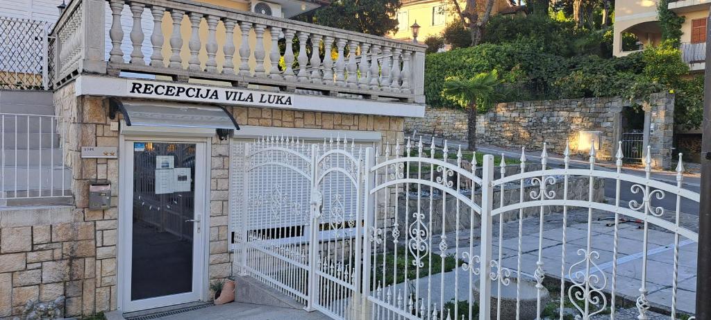 ein weißes Tor vor einem Gebäude in der Unterkunft Guest house Vila Luka 2 in Portorož