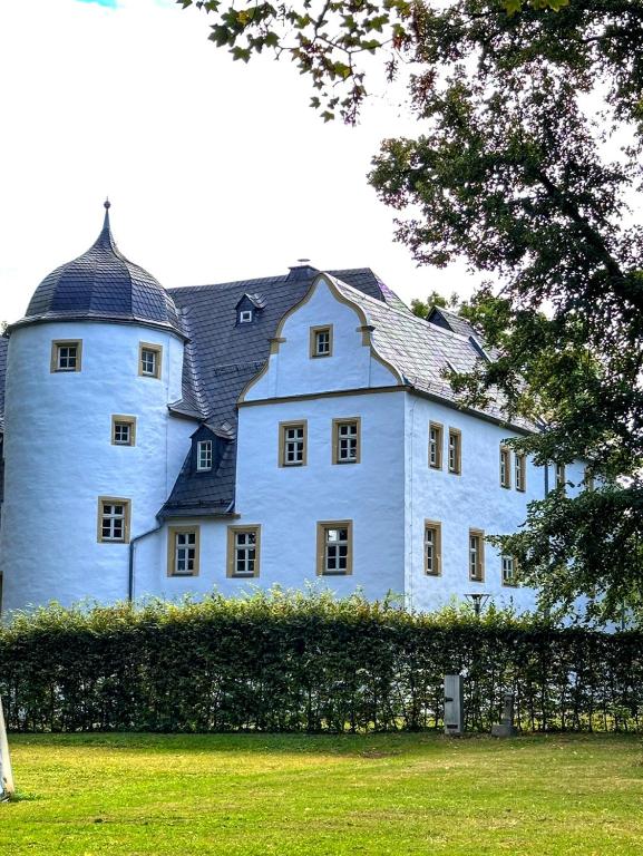 a large white building with a black roof at Schlosshotel Eyba in Saalfeld