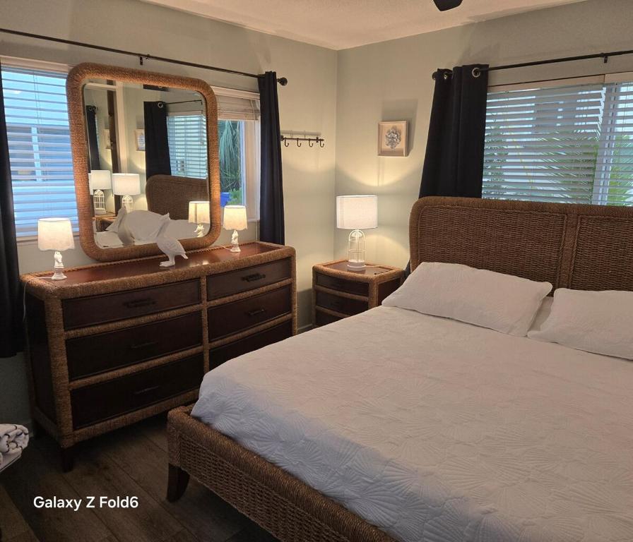 a bedroom with a bed and a dresser with a mirror at Cozy island apartment in Pompano Beach
