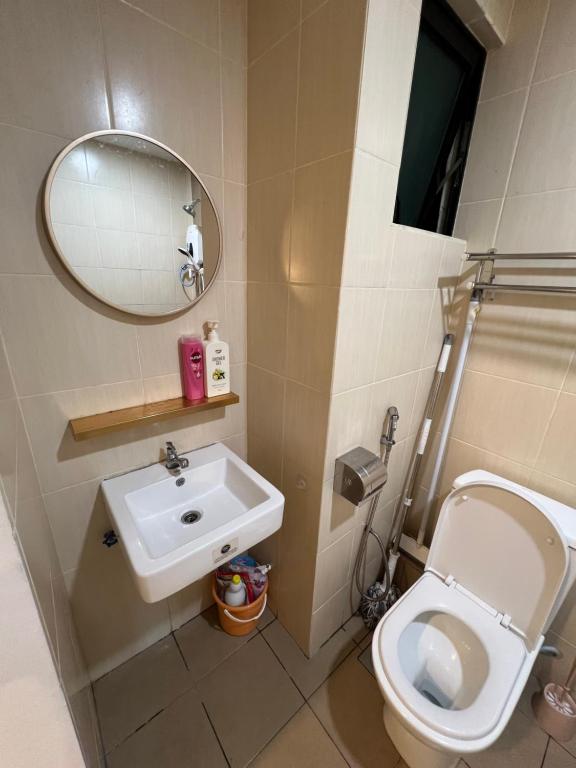 a bathroom with a sink and a toilet and a mirror at ITCC Manhattan Suites by Cozyqa Stay in Donggongon