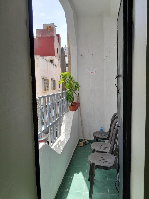 a balcony with chairs and a potted plant on it at Casa maartil in Martil
