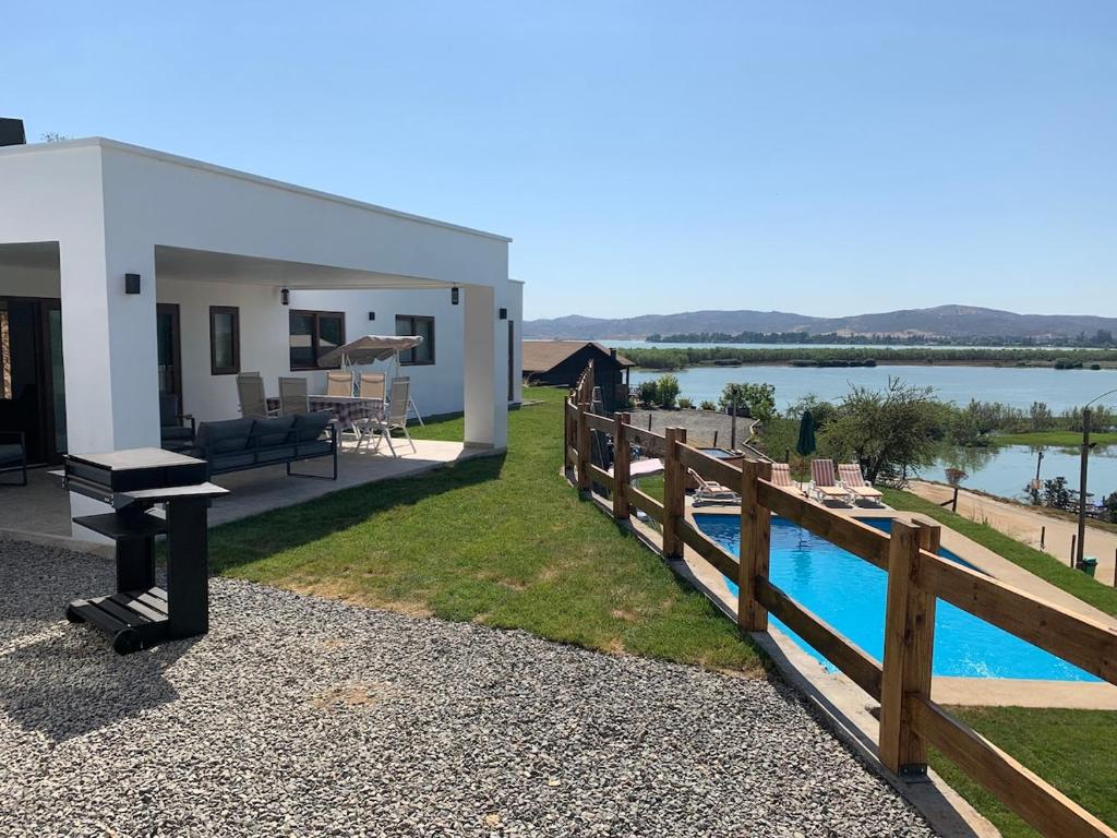 a house with a swimming pool and a fence at Casa con vista lago Rapel in Las Cabras