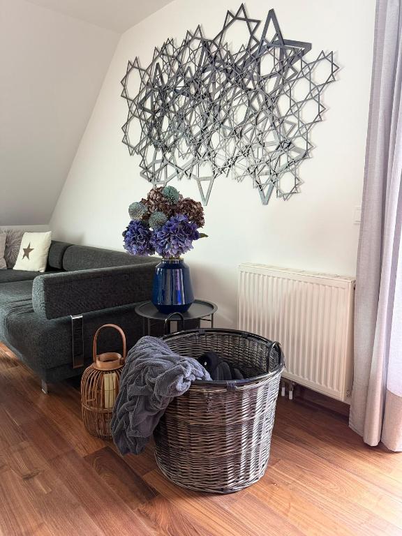 una sala de estar con sofá y un jarrón de flores en Das Genner - Suite am Bisamberg, en Klein-Engersdorf