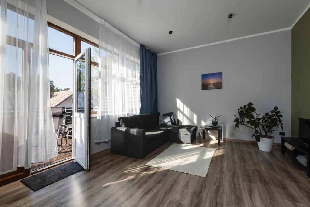 a living room with a couch and a large window at SunCoast terrace apartment in Saulkrasti